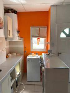 Detalle de la cocina y el lavadero de Murmullos de Sueño, pintado en naranja