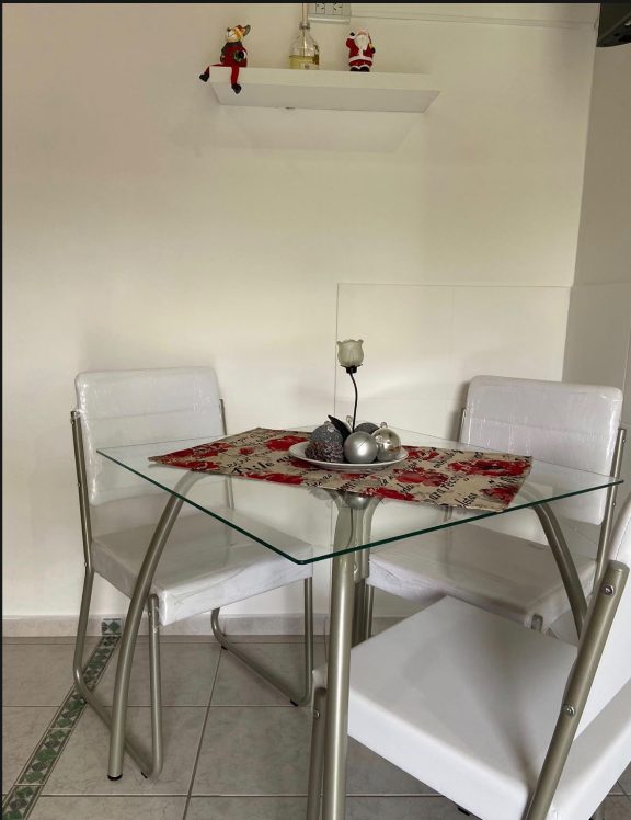 Mesa de estar de Murmullos de Sueño con sillas blancas, lista para desayunar o compartir un café