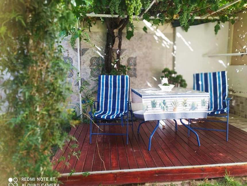 Patio con parral de Murmullos de Sueño, con mesa y sillas para descansar al aire libre